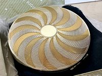 compact closed showing guilloché swirl pattern