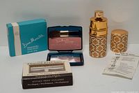All three items: blush box and open compact with brush, Revlon eyelashes box, Madame Rochas atomizer and insert