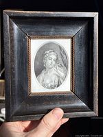 Framed engraving held in hand