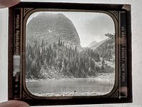 Front view of lantern slide held to light showing image and border text