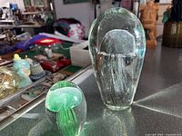 Both jellyfish paperweights side by side showing size difference