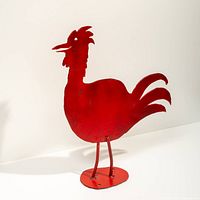 Front view of red metal rooster sculpture on base