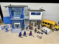 Wide view of police station, guard tower, school bus, van, figures and accessories arranged on tabletop