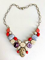 Front view of sterling silver bib necklace showing multicolored stones and chain