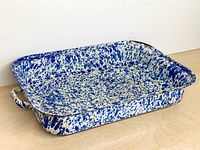 Oblique view of enamel splatter pan showing interior and one handle