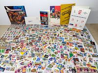 Large spread of loose stamps with Canada Post booklets and pamphlets displayed at back