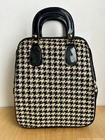 Front view of houndstooth handbag showing shape, pattern and handles