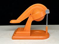 Side profile of orange plastic lever juicer showing full form