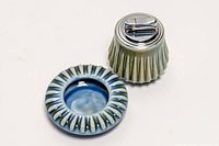 Porcelain ashtray front with lighter on side displaying chrome top and fluted sides