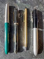 Four pens side by side on tabletop