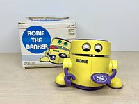 Robie coin bank in front of original box