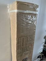 Full view of sealed cardboard box containing projector screen