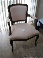 Front view of wooden armchair showing upholstery and frame details