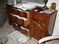 Full view of the wooden server with six drawers partially open and two cabinet doors visible, showing intricate handles and some surface wear.