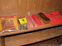 Photo of various wood carving sets and diamond needle files on wooden shelf
