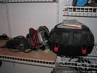 Photo showing both Skilsaw circular saw and black carrying case with manuals on top.