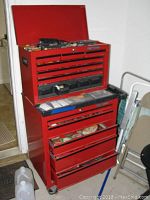Front view of red Craftsman tool box with drawers open and items inside on rollers.