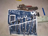 Photo of Medalist 14-piece combination wrench set in blue roll-up pouch with six pipe wrenches and two pipe cutters behind showing overall lot contents.
