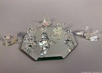 Group shot of nine crystal figurines arranged on hexagonal mirror base