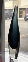 Full side view of tall slender teal-on-clear glass vase