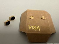 Both pairs of earrings, hearts on display card marked 14K, oval onyx pair beside