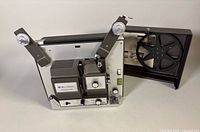 Front view of Bell & Howell Filmosound Eight projector with reel arms extended and cover open