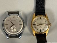 Front view of both watches displaying dials, cases and absence of strap on Hysa