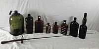 Group shot of fencing foil and eight bottles