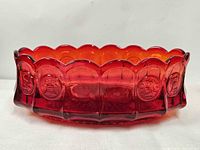 Top angled view of ruby red coin glass bowl showing scalloped rim and overall shape