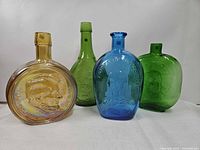 Group shot of four colored Wheaton glass flasks