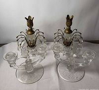 Two identical crystal and brass waterfall candelabra showing bases, arms, prisms, and brass finials
