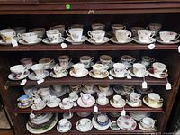 Multiple shelves filled with floral porcelain teacup and saucer sets