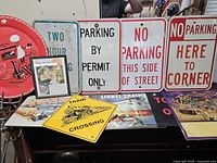 Group of metal street and advertising signs on table