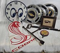 Group shot showing clock, hubcaps, Cobra sign, tools, framed print