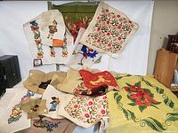Mixed lot overview showing multiple needlepoint pieces spread out