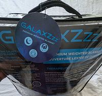 Front of packaged GALAXZzz weighted blanket with hang tag