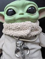 Front view showing Grogu plush head, robe, pendant