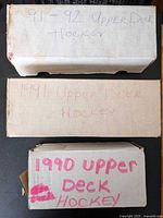 Three labeled cardboard long boxes containing Upper Deck hockey cards for 1990, 1991 and 1991-92 seasons