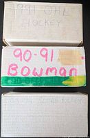 Three labeled card boxes stacked; handwriting shows set years and brands