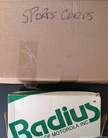 Top view of closed cardboard boxes labeled 'Sports Cards' and 'Radius'