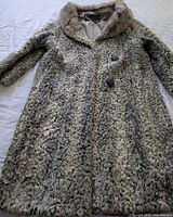 Full view of grey-ivory curly lamb fur coat showing collar, buttons and overall length