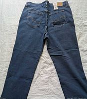 Full back view of jeans displaying color, cut, and rear pocket design
