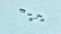 Six loose diamonds of varied cuts on plain background