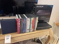 Overall lot showing player, DVDs stack, disc wallet and product box