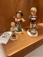 All three figurines grouped on shelf