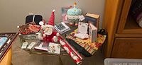 Overview of lot on glass table including plush toys, greeting cards, wrapping paper, books