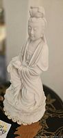 Front view of white porcelain Guanyin statue on lotus base