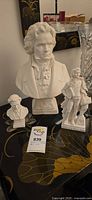 Group view of three plaster composer sculptures