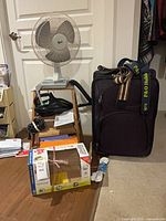 Group shot showing suitcase, fan, stepstool with vacuum, ShamWow cloths, extension cord and door hanger