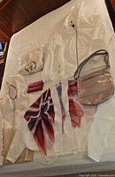 All clothing pieces, bags and wallet laid out on bed